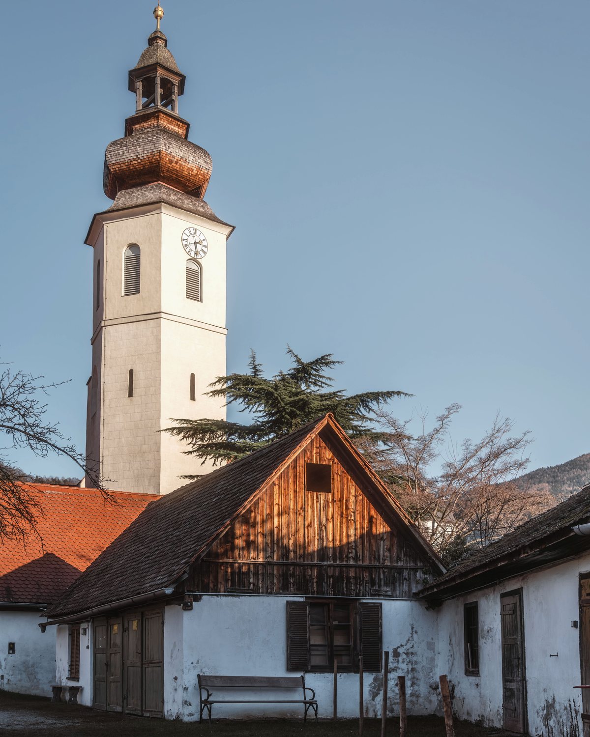 Älteres Wohnhaus mit Kirchturm im Hintergrund